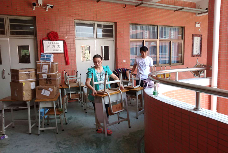 mk体育志愿者及家长用消毒液擦拭桌椅